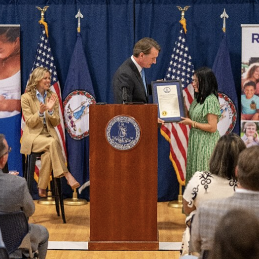 Governor at podium presents award